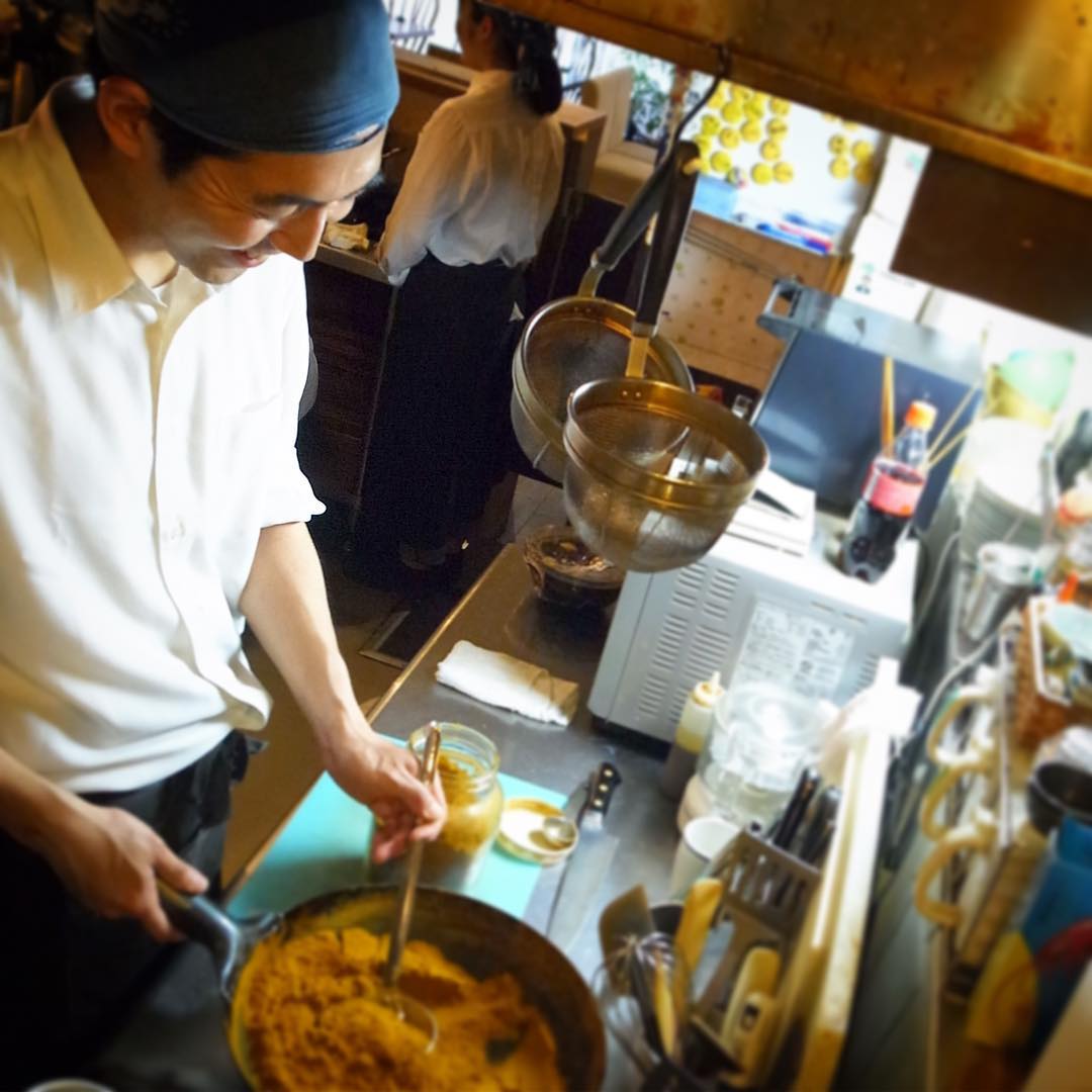 今朝届いたあれこれスパイスをすぐさまキッチンスタッフナベさんが中華鍋で当店オリジナルブレンドのカレーにひと炒りしてくれたところです！向こうに立ってるのはやぎちゃんですね（笑）（お）