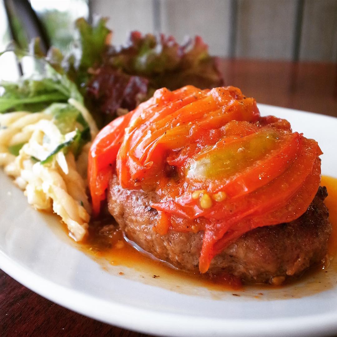 人気の夏ランチは「フレッシュトマトのハンバーグ定食」！トマト丸々一個分をいっしに焼いてのっけ盛り！そのままさっぱりソース代り！やさしいお味ですいすいたべられますよ！ぜひ！（お）