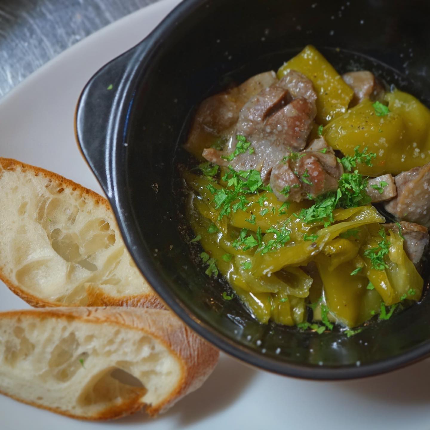 地味〜に新メニュー出ております「砂肝と甘長とうがらしのアヒージョ」です。
砂肝はコトコトじっくりやわらかーくコンフィにしてあるものを、甘長とうがらしと合わせてアヒージョにしました。唐辛子ほど辛くないけど、程よい刺激と風味が良くて、スペイン料理だけど南米料理みたいな趣もありますね。バケットをおつけしますので、オイルもヒタヒタして召し上がって！（麻）