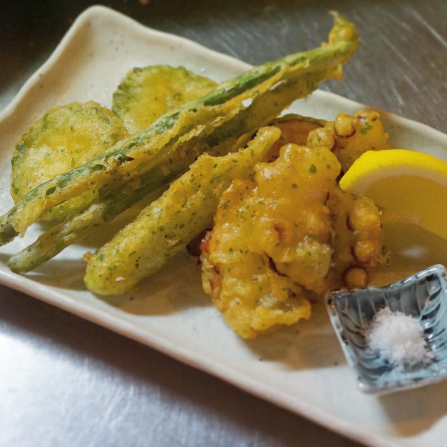 夜の揚げ物新メニューは、ありそでなかった「タコと夏野菜のポルトガル風天ぷら」!どこら辺がポルトガル？と言いますと、まずタコとインゲン、これがポルトガルではメジャーな天ぷらな訳です。衣には味がついていて、ハーブが色々入っている…これにリトスタ風アレンジを加えると、野菜は夏野菜色々になり、衣には隠し味のガラムマサラが入っちゃいます。ほんのり異国情緒漂う天ぷらは夏らしさ満点！　さあ、おひとつどうぞ！（麻）