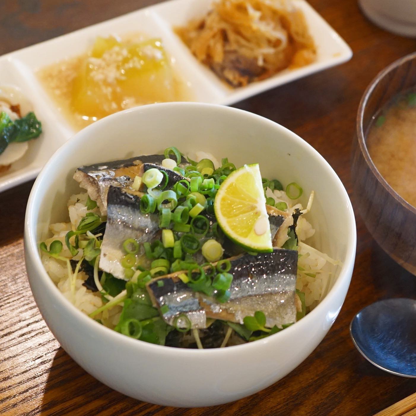 今週のごはんものは、さんまのコンフィと香味野菜ごはんです！本日はランチでもご提供しましたが、基本的には夜のみのメニューになります。
旬のサンマをローズマリーやローリエなどのハーブと一緒にオリーブオイルで低温で煮る自家製コンフィ。香味野菜と海苔の上に、キリッと塩味のきいたさんま、路地もののスダチを絞っていただくと爽やかなどんぶりご飯になります。途中でお醤油をかけると今度は和風テイストに早変わり。1杯で2度美味しい、旬のごはんです！（麻）