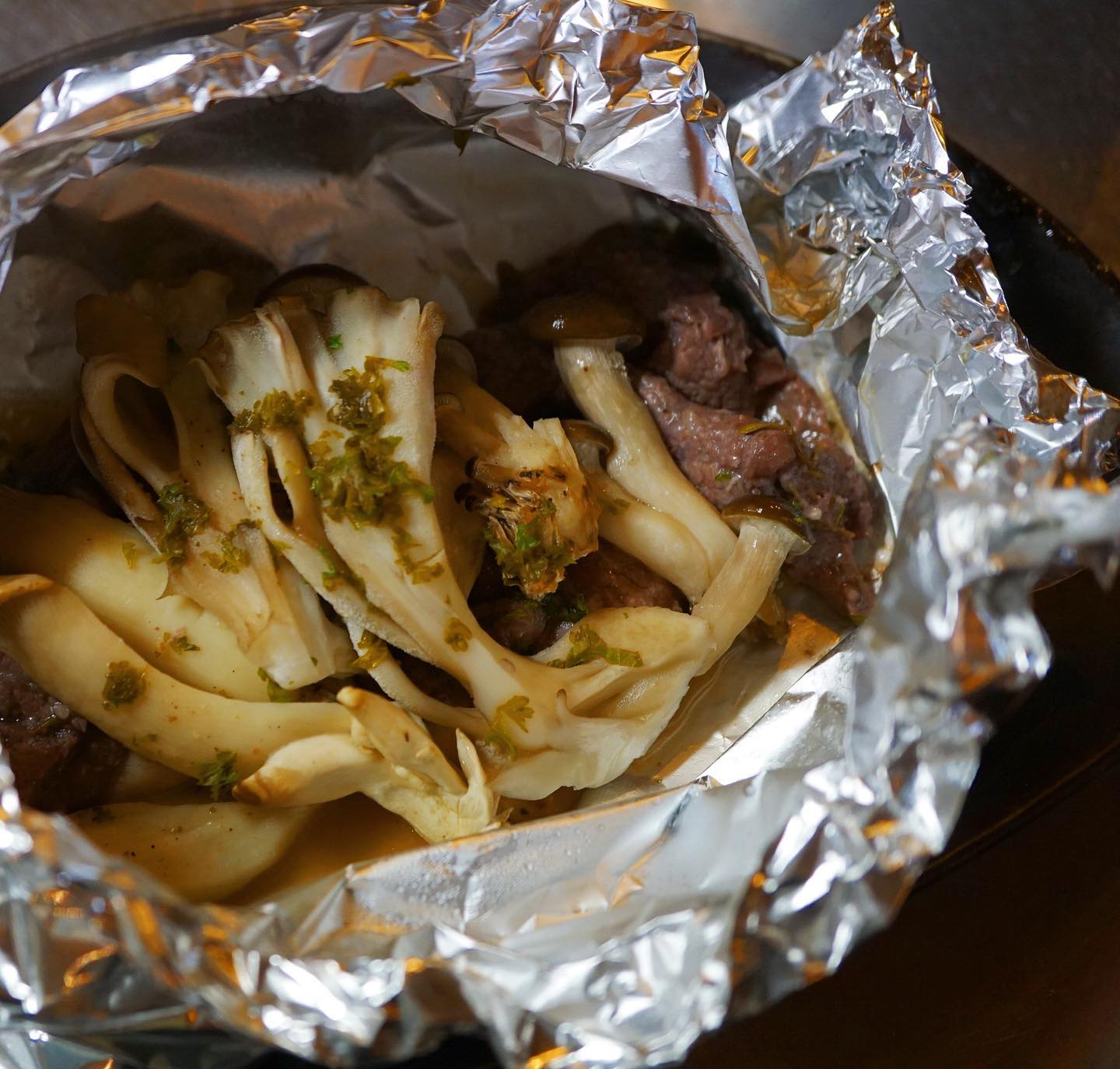 インスタ映えしないわねー、ホイル焼きって！　でも美味しいよ、新メニューは「牛肉の塩麹漬けときのこのホイル焼き」。名前だけ見ると和風な気がするけど、タイムと赤ワインで風味をつけて塩麹漬けにした牛肉はワインに合うと思いますよー。レモンを絞って、バターを乗っけて旨味たっぷりでもさっぱり仕上げてます。ご飯にもぜひぜひ！（麻）