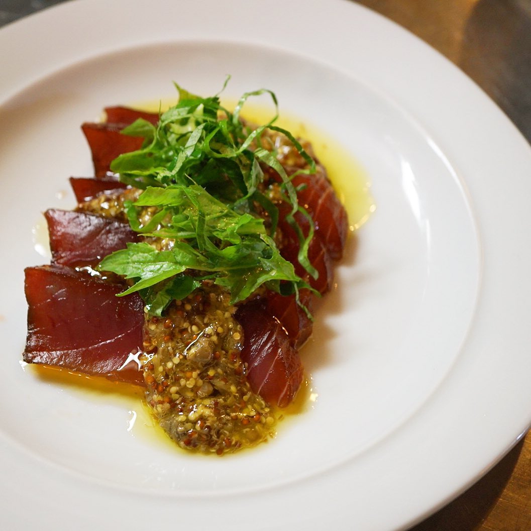 今週の冷前菜お魚部門は、まぐろの和風カルパッチョ！　まぐろはたまり醤油漬けにしております。カルパッチョソースは粒マスタードとケイパーの個性的な酸味にレモンを絞って爽やかに。昨年のクリスマスディナーで好評だった一品です。（麻）