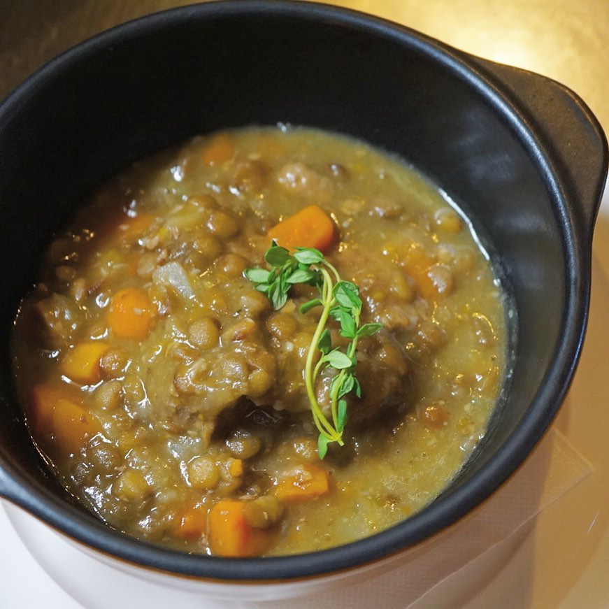 見た目は地味だけど、密かなモテモテメニュー「豚のコンフィとレンズ豆の煮込み」です。ハーブと一緒にラードでコンフィにした豚バラ肉は柔らかーい！レンズ豆と香味野菜、タイムと一緒に香りよく煮込みました。パンにもごはんにも合いますよ〜。店長ミヤザキ食べたいやつです！（麻）