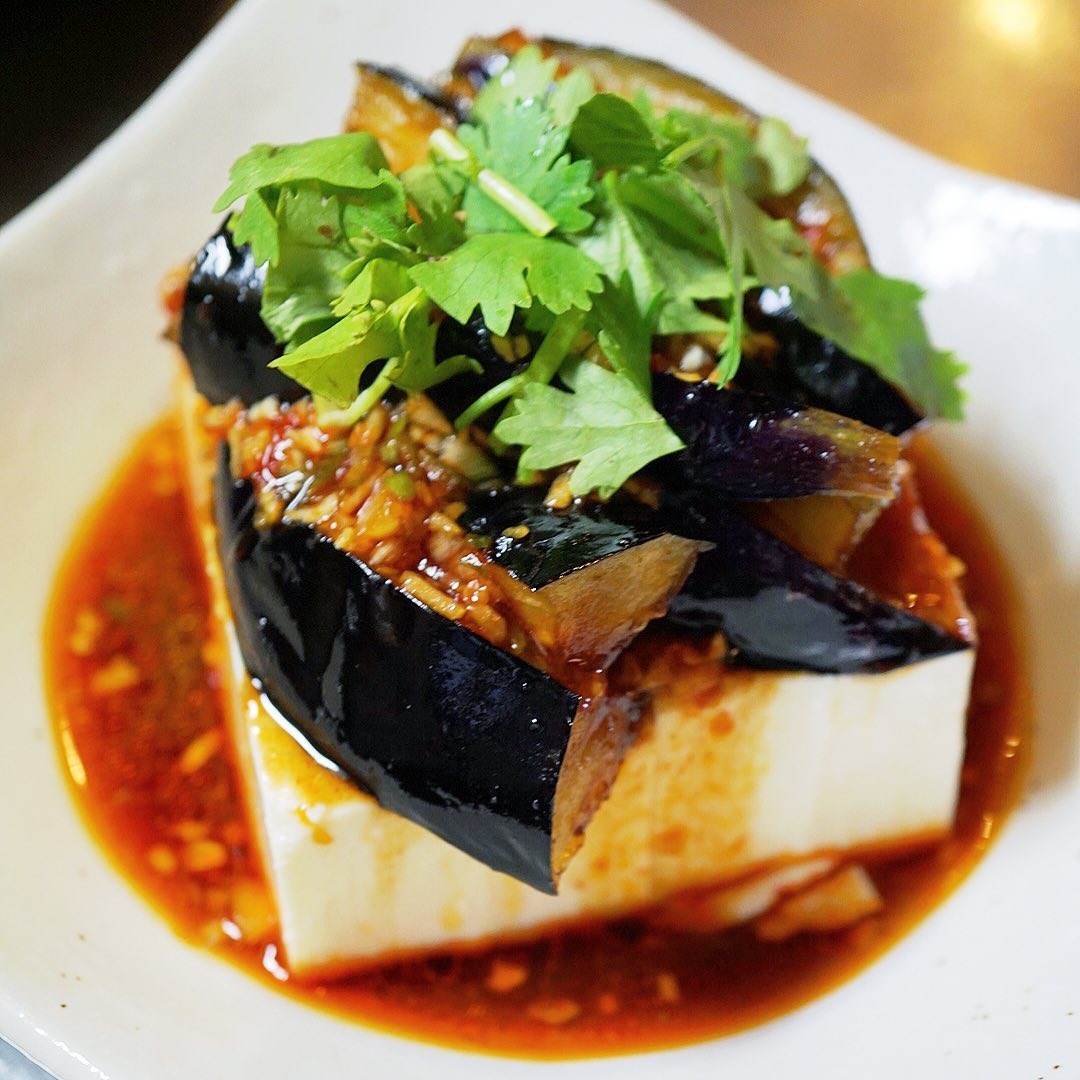 さてと当店夏の冷やっこといえばご存知？「揚げ茄子のリャンパン豆腐」！
お豆腐の上にエイヤと揚げ茄子をのっけたら、たっぷり薬味の中華風たれをじゃじゃっとかけてひんやりスパイシーな旨口冷やっこ！（お）