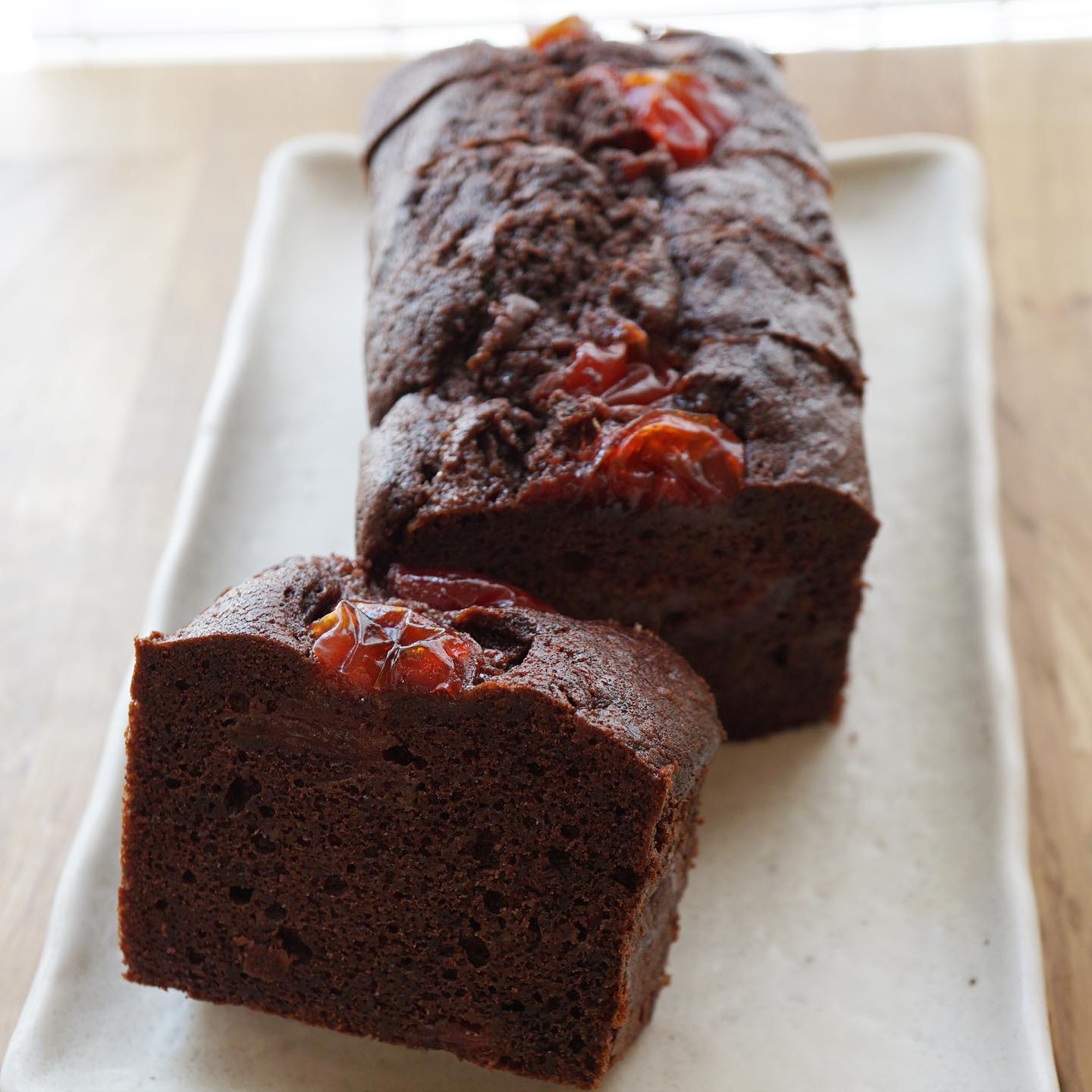 パウンドケーキが切り替わりましたよー！　今回は「すももとココア」です。レアチーズケーキのソースや、サワークリームと一緒に小さなケーキにも使っておりました自家製すももコンフィチュールをココア生地のパウンドケーキに焼き込みました。しっかり濃いめのココア生地と甘酸っぱいすもものハーモニーは、フォレ・ノワールのイメージです。見た目は大人だけど味わいは意外と優しいですよ。他のすももデザートは終了となりますので、よろしくお願いします！（麻）