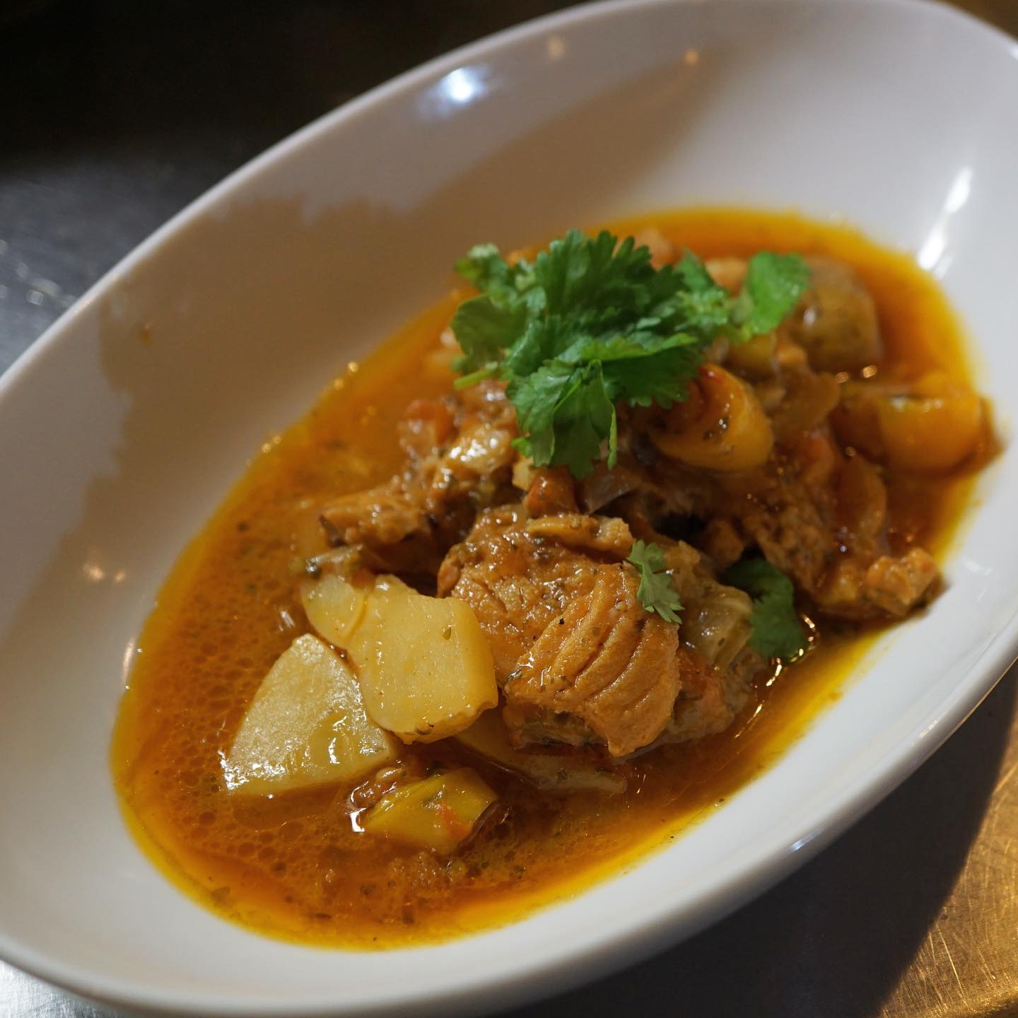 最近お菓子の研究ばっかりしてない？　…いや、料理だって勉強し続けたいんだけどね！　と自問自答する店長ミヤザキ、新メニューはモロッコ料理「白身魚のスパイスレモン蒸し」です。モロッコに行ったことないのに、モロッコ料理のレシピを見ると胸が高鳴る、絶対美味しいに違いない！という料理にたくさん出会います。これは本来タジン鍋で作るものをアレンジしたものです。スパイスの香りとレモンの酸味、白身魚の旨味とトマトの風味のバランスをとって、ワタシの中の「この味だ！」というところに落とし込んでいく面白さ。これだから料理はやめられぬ。ぜひ味わってみてくださいね。
ちなみに最近店長はアラブ料理とギリシャ料理の本を買いました！（麻）