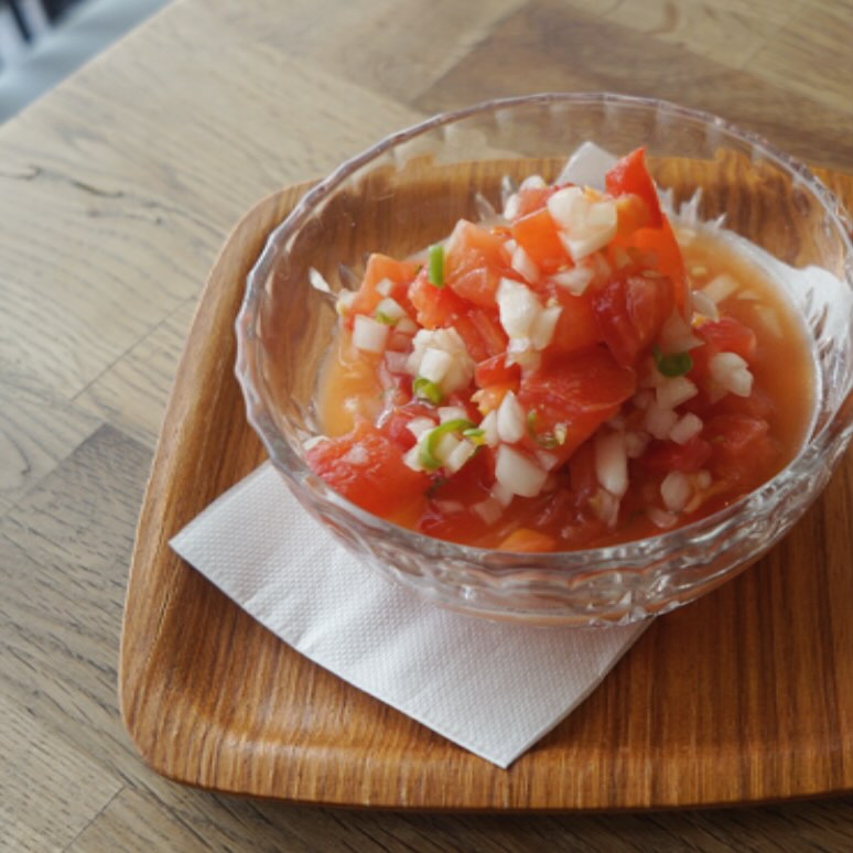 明日からお盆休みに入らせていただきますよ、のリトスタですが、休み前に小さな新メニュー「トマトと青唐辛子のマリネ」お出ししております！
完熟トマトは角切り、みじん切りの玉ねぎと爽やかな辛みの青唐辛子と合わせて、軽く酢と胡麻油、塩でマリネした雲南省式トマトサラダ！スプーンですくってひとくち頬張れば、ピリリと辛くて酸っぱい、程よい刺激が夏の暑さにピッタリです。ぜひぜひ！（麻）