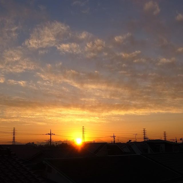 屋上に干したソファのクッションを取り込みに上がったら見事な夕焼け…夕日の右隣りの台形が富士山ですね（お）