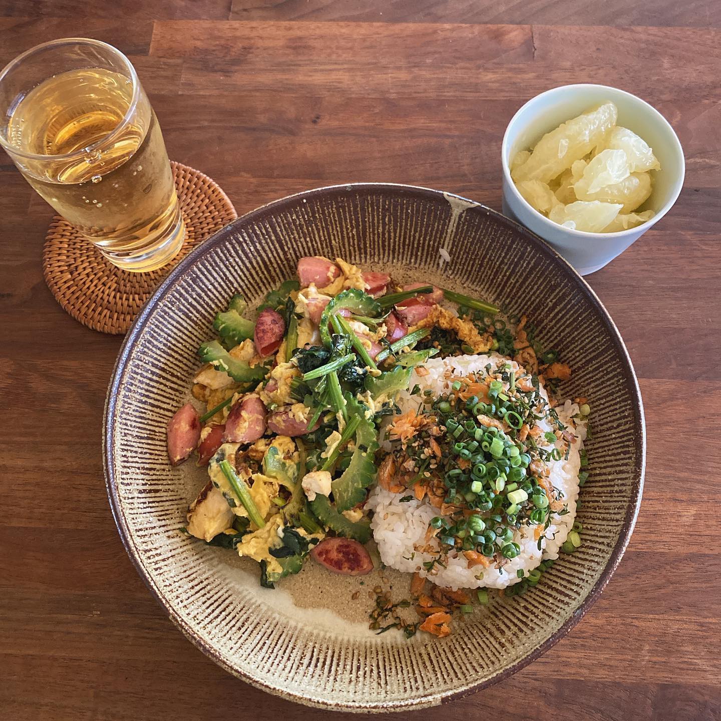 ゴーヤーチャンプルー風ごちゃ混ぜ炒め。ゴーヤと豆腐とほうれん草とウインナーをごま油と塩でちゃっちゃと炒めて卵でとじる。卵には酒と薄口醤油。
お店で作った鮭と人参葉のそぼろを、ごはんにのっけてさらに小ネギをのせる。グレープフルーツと、トワイニングのレディグレイ水出しアイスティ。栄養バランス重視の適当ワンプレート！