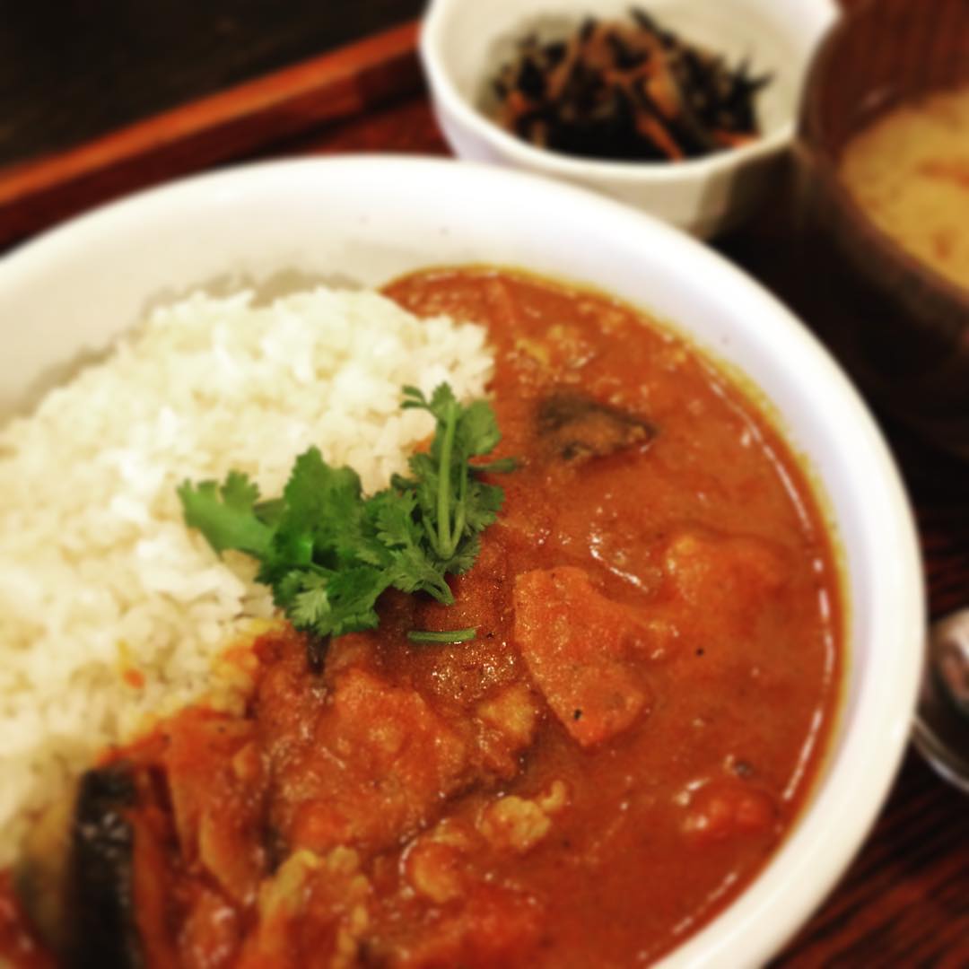 本日のまかない、「店長特製・まかないカレー」です！ランチメニューが続々売り切れたので、店長が急遽作ってくれたカレーです。肉だんごトマト煮のトマトソースをベースに、豚バラ、ウインナー、野菜がゴロゴロ。スパイスやパクチーの香りが素敵です。メニューにないのが残念なくらい美味しかったですよ！（うめ）