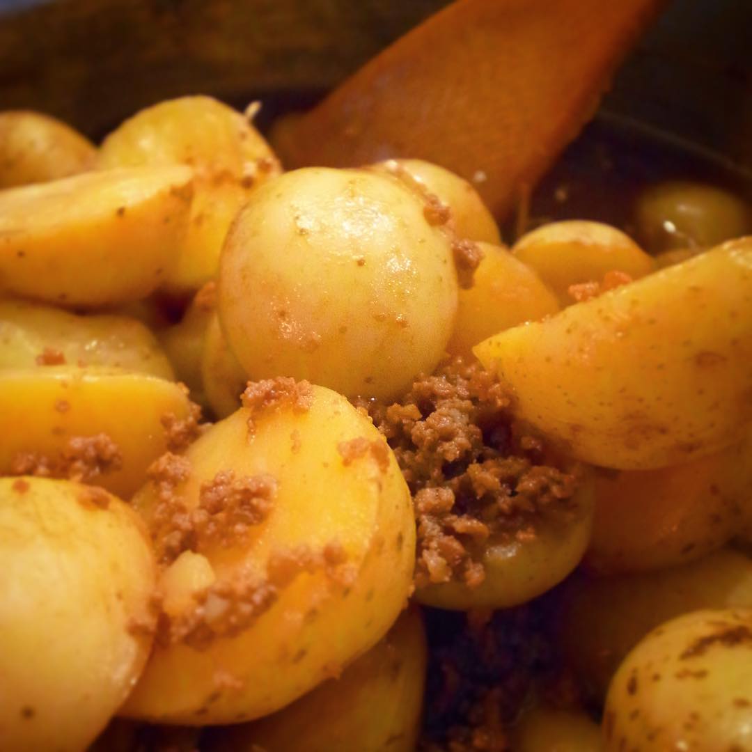 ひょいとのぞいた大鍋には一度さっくり揚げたかわいいサイズのころころ新じゃが！そぼろといっしょに甘辛〜くこっくりこっくり煮付けたら、仕上げにバターとお味噌を少々、しっかり旨味のこっくり煮ですよ！（お）