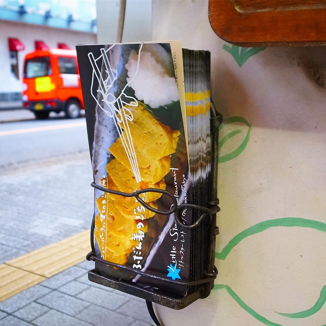 さて！あー、ワタクシしばらくうんうんがんばって作っておりました当店の新パンフレット！本日納品からの…昨日サビ落とししてきれいになった下看板のホルダーに入れて、すでにみなさんにお取りいただけるように設置済み！（笑）ぜひぜひおひとつお持ち下さいね！（お）