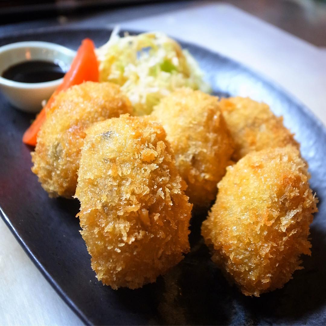 さてと今夜のビールのお供はしっとりあつあつ！ヤケドに注意！「里芋コロッケ」！ふっくら蒸した里芋にしいたけの旨味とれんこんのシャキシャキ、さらにエビのぷりぷりを加えてからりと揚げたて小さな俵のコロッケ！ウスターソースでどうぞ！（お）