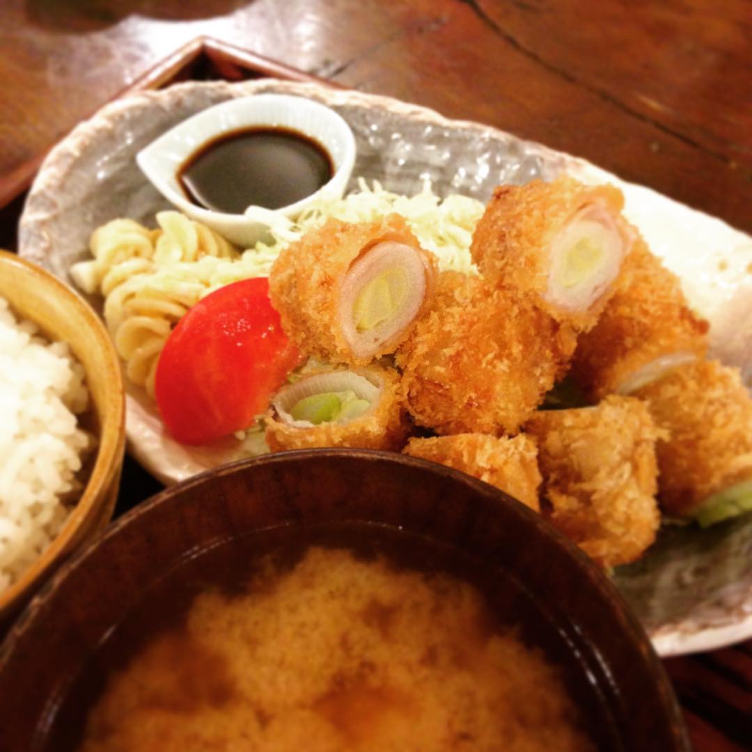 今日の日替りは「長ねぎの豚肉巻きフライ定食」でした。去年から登場したメニュー。長ねぎの甘さを楽しめるメニューですが、いかんせん噛むと長ねぎがニュ〜っと出てきて滑稽なことになりがちでした。が、今は一口サイズになりましたので滑稽なことにならないです。また登場の際はぜひ頬張ってみてくださいね。(うめ）