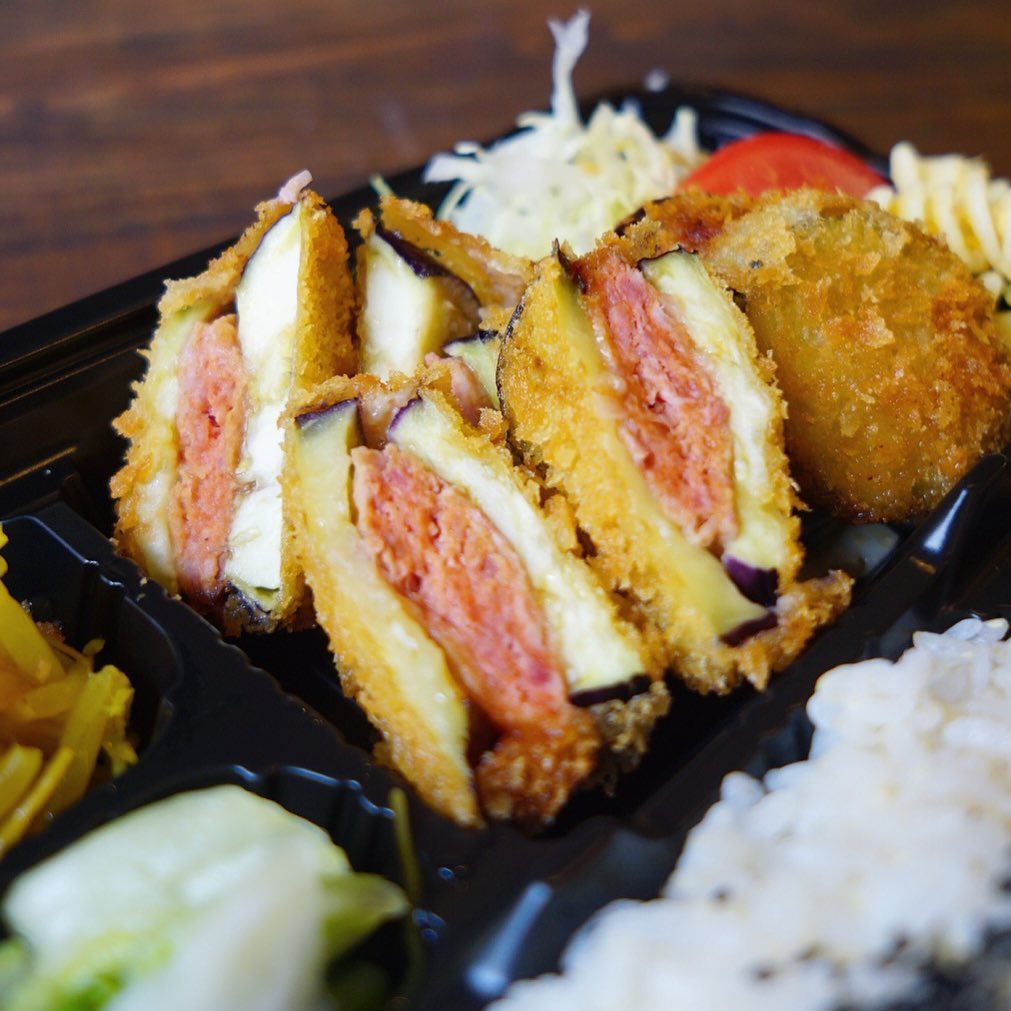 さてっ！今日の日替わりお弁当はランチ時代も人気でしたね！「茄子の挽き肉サンドフライ」！なんたってあつあつジューシー！肉汁を茄子がしっかり受け止めて旨味が満点ですよー！たべたーい！（笑）（お）